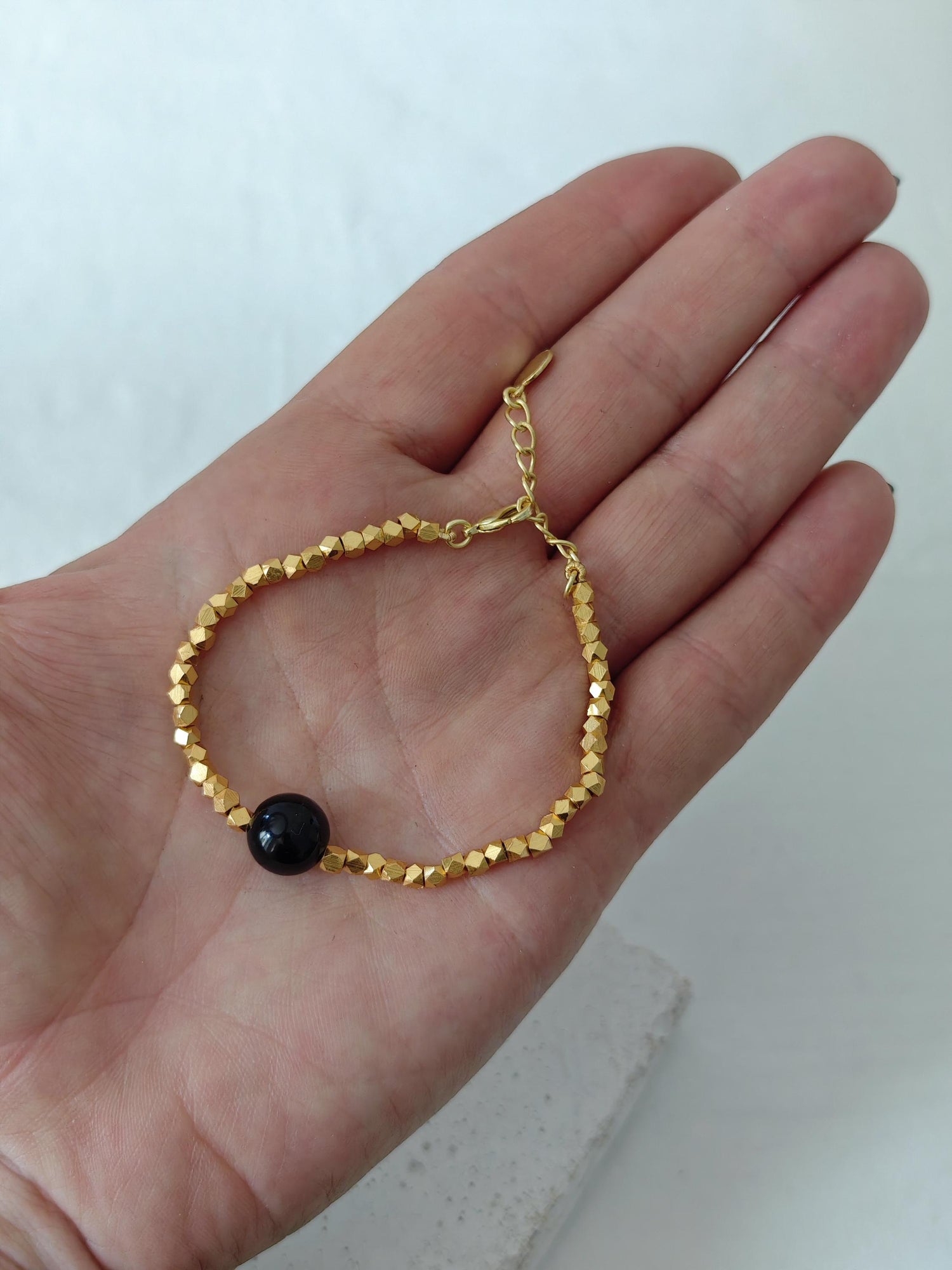 The Golden Glow Of The Night -  handgefertigtes Perlenarmband mit 18K Vergoldung und schwarzer Onyx-Perle