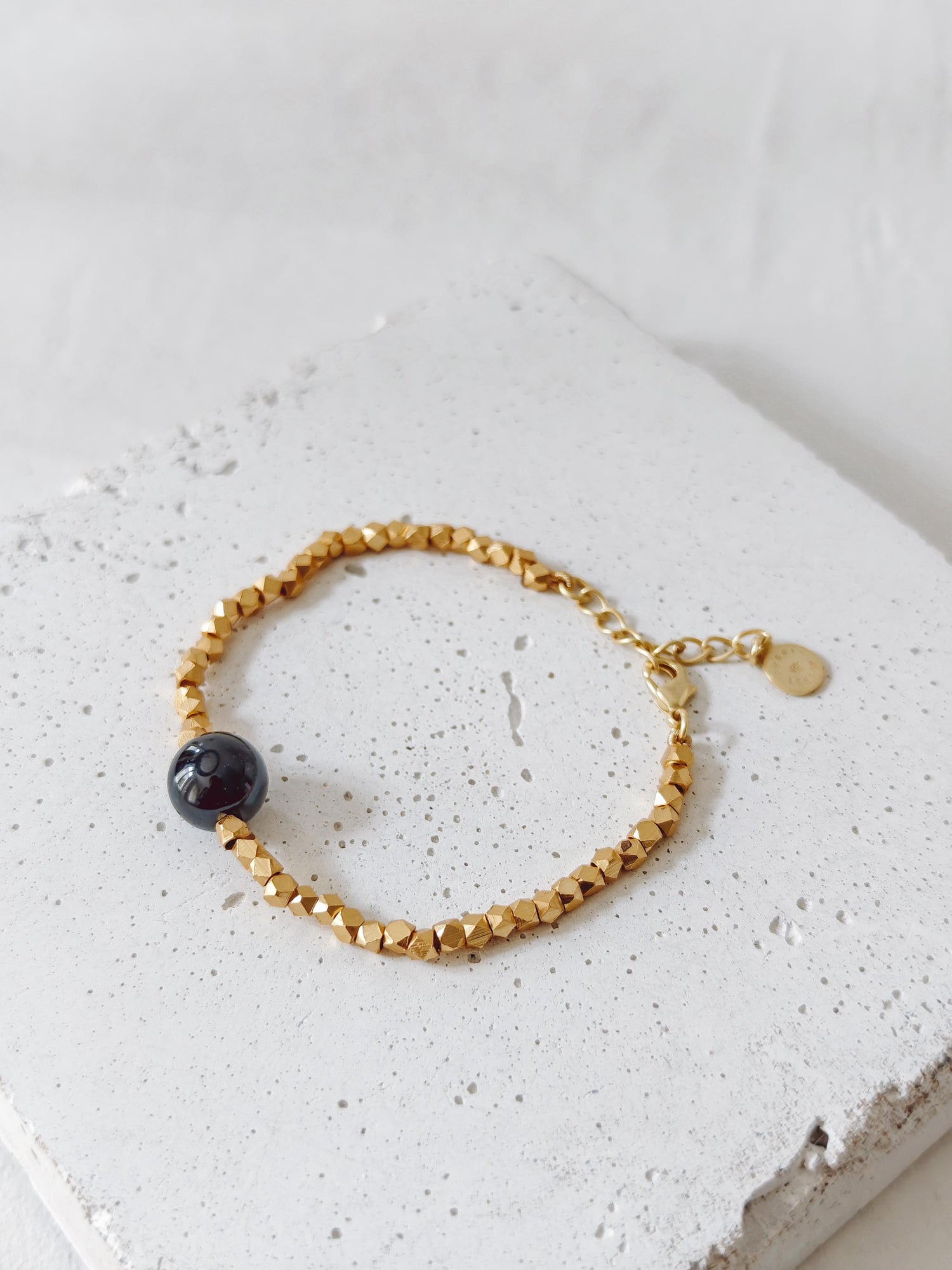 The Golden Glow Of The Night -  handgefertigtes Perlenarmband mit 18K Vergoldung und schwarzer Onyx-Perle