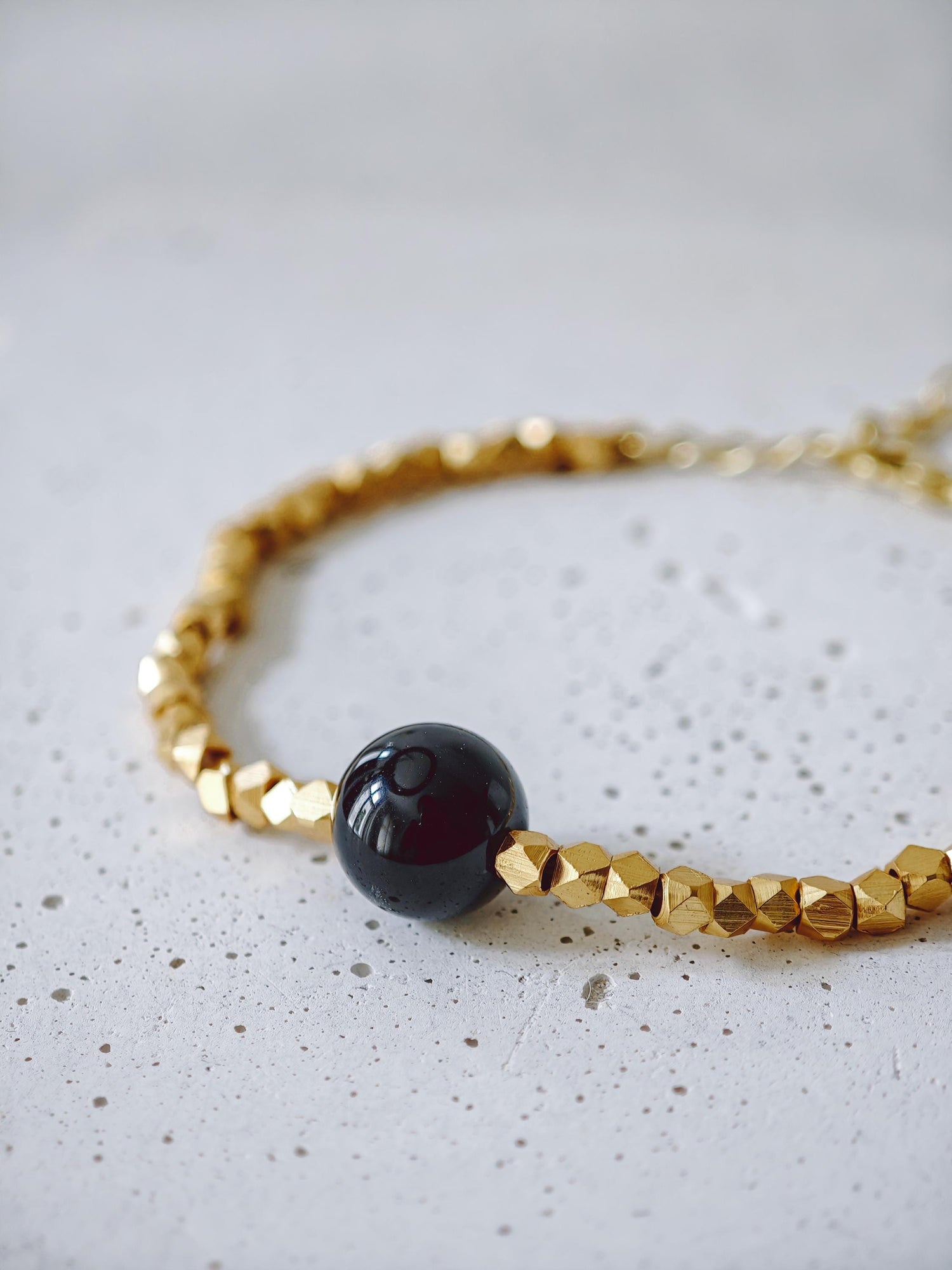 The Golden Glow Of The Night -  handgefertigtes Perlenarmband mit 18K Vergoldung und schwarzer Onyx-Perle