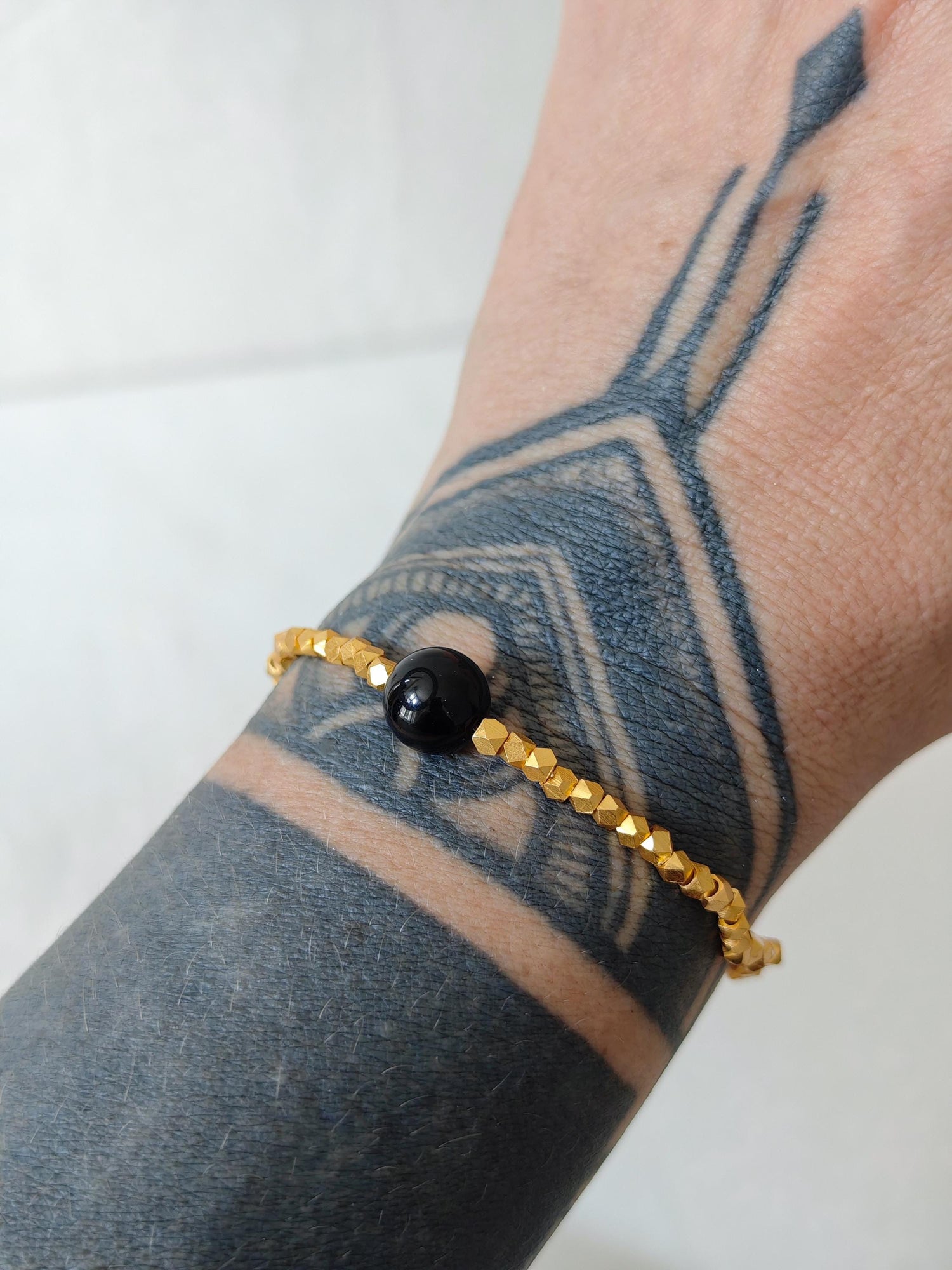 The Golden Glow Of The Night - handgefertigtes Perlenarmband mit 18K Vergoldung und schwarzer Onyx-Perle